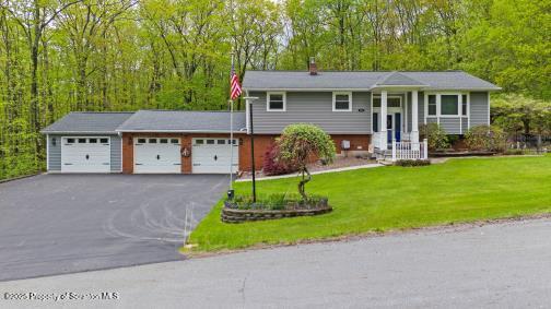 210 Willow Dr, Jefferson Twp, PA 18436 - bi-level home with an attached garage, driveway, a front lawn, and a chimney