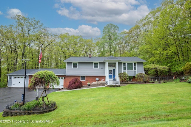 210 Willow Dr, Jefferson Twp, PA 18436 - split foyer home with asphalt driveway, an attached garage, brick siding, and a front lawn