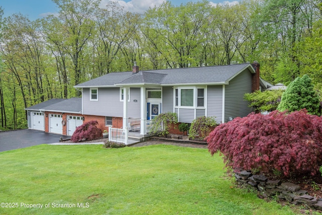 210 Willow Dr, Jefferson Twp, PA 18436 - raised ranch with a chimney, driveway, a front yard, brick siding, and an attached garage