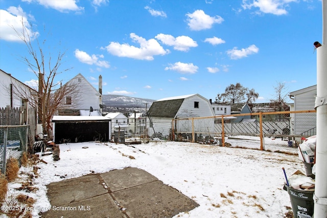 yard covered in snow featuring a detached garage and fence