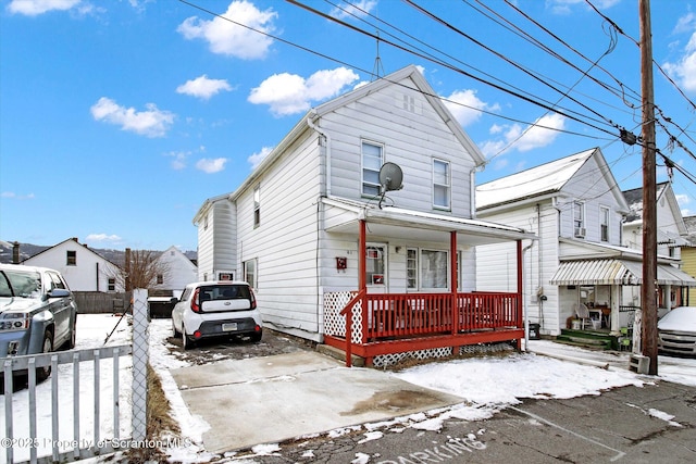 view of front of home with a porch and fence