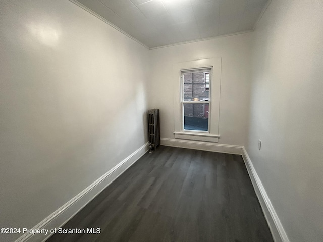 unfurnished room featuring crown molding, dark wood-type flooring, and radiator