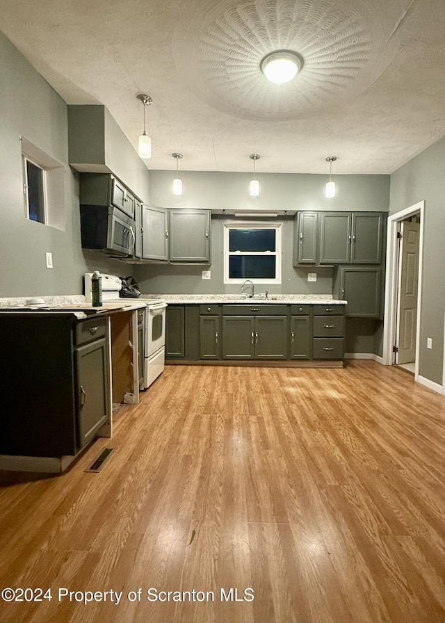 kitchen with a textured ceiling, sink, pendant lighting, light hardwood / wood-style flooring, and white range with electric cooktop