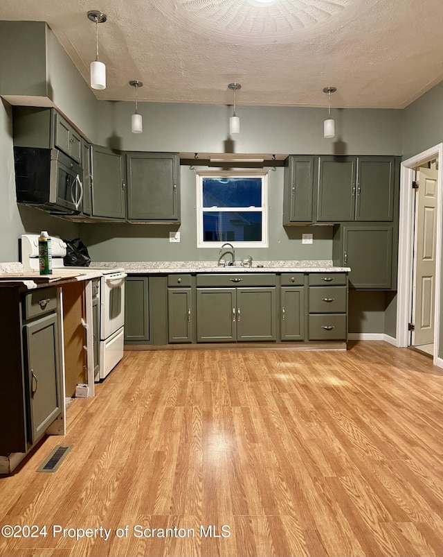 kitchen featuring a textured ceiling, sink, electric stove, hanging light fixtures, and green cabinets