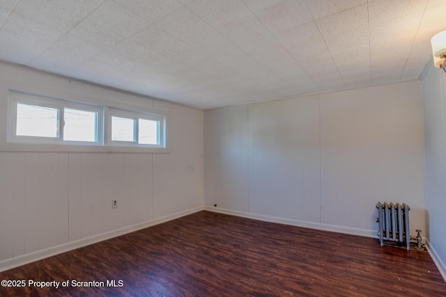 506 Short St, Throop, PA 18512 - spare room featuring wood finished floors, baseboards, and radiator