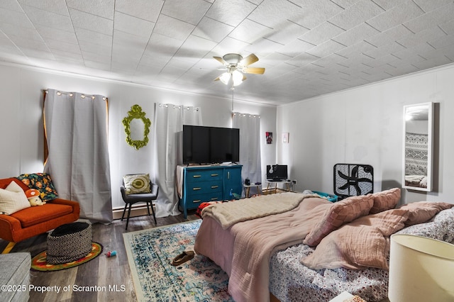 bedroom featuring wood finished floors and ornamental molding