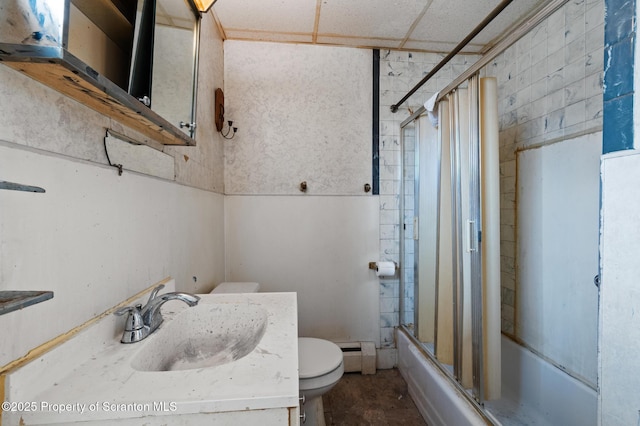 bathroom featuring a baseboard heating unit, enclosed tub / shower combo, toilet, and vanity