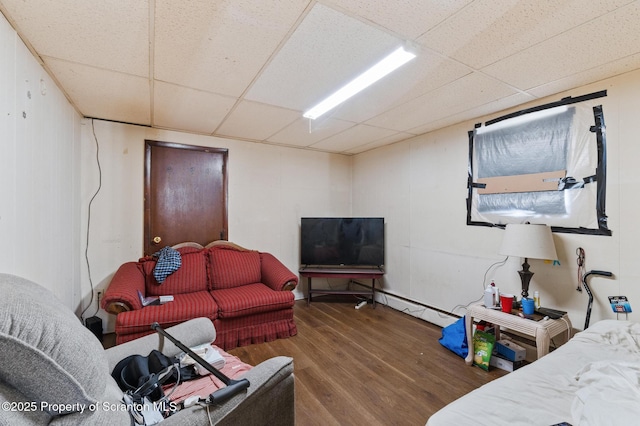 living room featuring a baseboard radiator, wood finished floors, and a drop ceiling