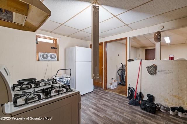 kitchen featuring wood finished floors, freestanding refrigerator, range with gas cooktop, and a drop ceiling
