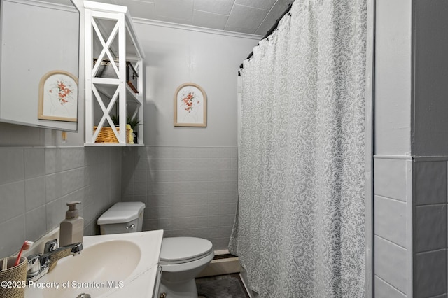 full bath with toilet, a shower with curtain, a sink, and tile walls