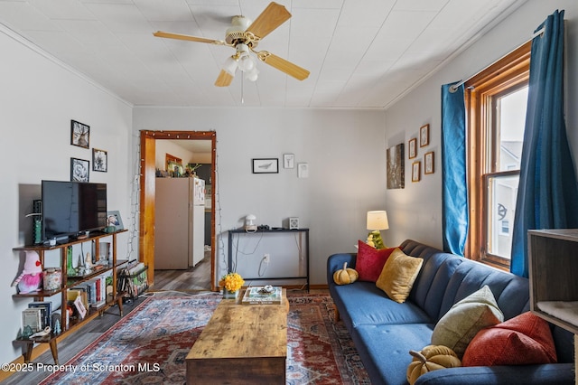 living room with ornamental molding, wood finished floors, and ceiling fan