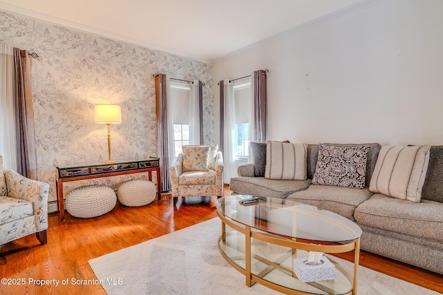 living room featuring wallpapered walls, a baseboard radiator, wood finished floors, and crown molding