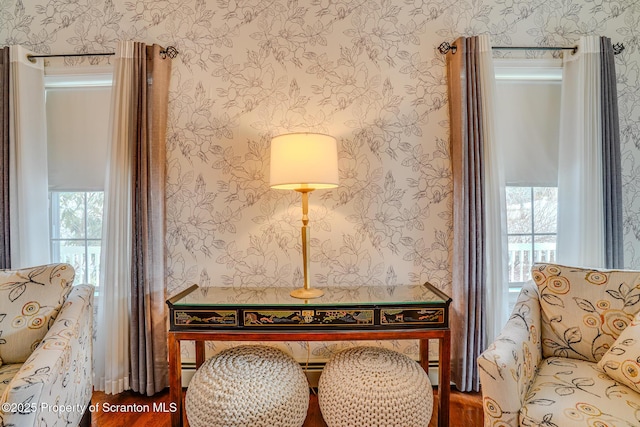 living area with plenty of natural light, a baseboard radiator, and wallpapered walls