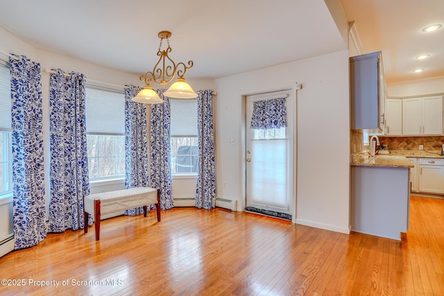 dining room with light wood-style flooring, a baseboard heating unit, and recessed lighting