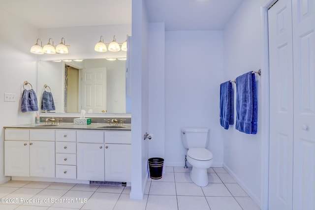 bathroom featuring double vanity, a sink, toilet, and tile patterned floors