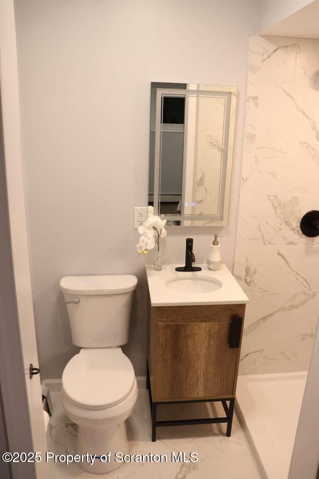 bathroom featuring vanity, toilet, and tiled shower