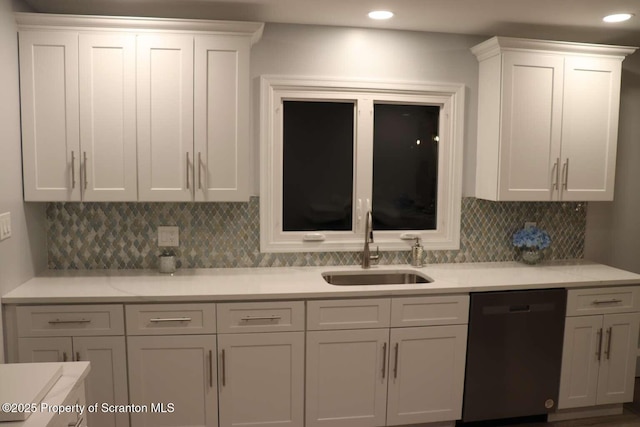 kitchen with white cabinetry, black dishwasher, sink, and decorative backsplash