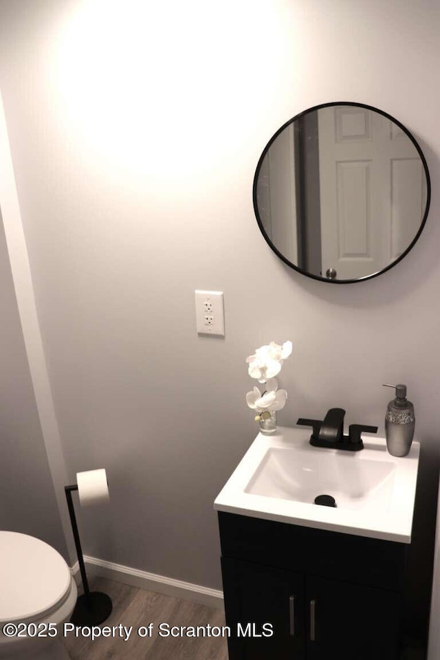 bathroom featuring vanity, wood-type flooring, and toilet