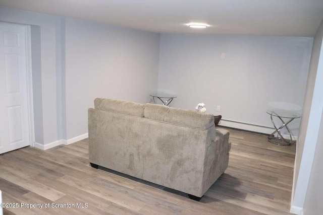 living room featuring hardwood / wood-style floors and a baseboard heating unit