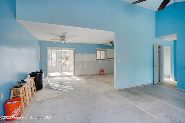 living room with ceiling fan and a high ceiling