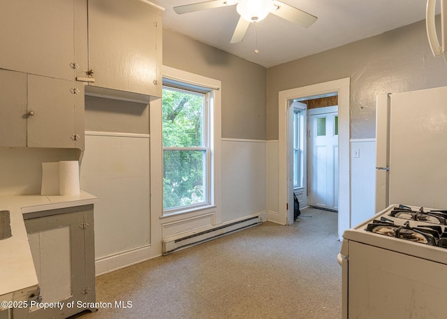989 Main St, New Milford, PA 18834 - kitchen featuring baseboard heating, white appliances, wainscoting, light countertops, and ceiling fan