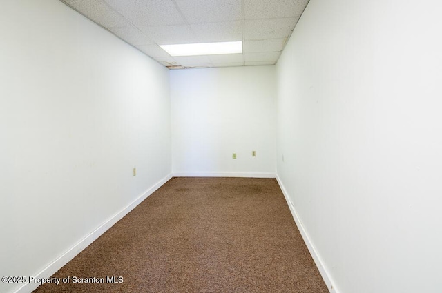 unfurnished room featuring carpet flooring, a paneled ceiling, and baseboards