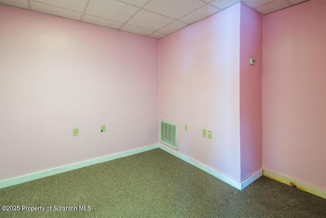 carpeted spare room with visible vents, a paneled ceiling, and baseboards