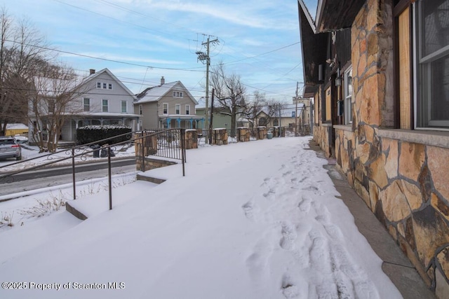 snowy yard featuring a residential view