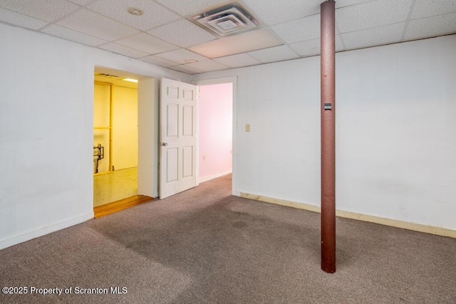 finished basement featuring carpet flooring, baseboards, visible vents, and a drop ceiling