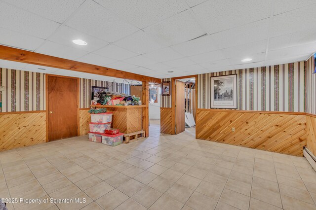 interior space featuring wallpapered walls, a wainscoted wall, and wood walls