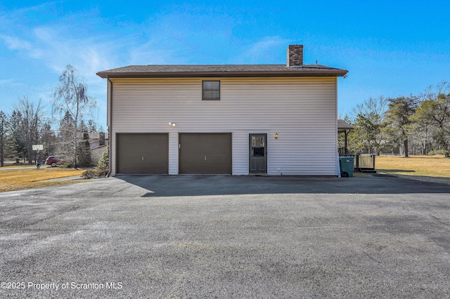 view of property exterior featuring a chimney and a garage