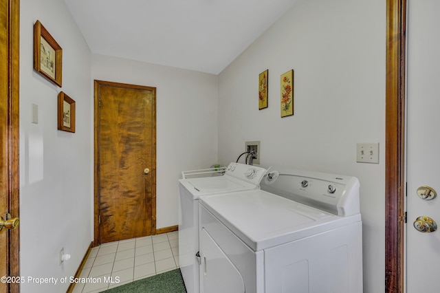 laundry room with laundry area, light tile patterned floors, baseboards, and washer and clothes dryer