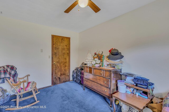 living area featuring a ceiling fan and carpet floors