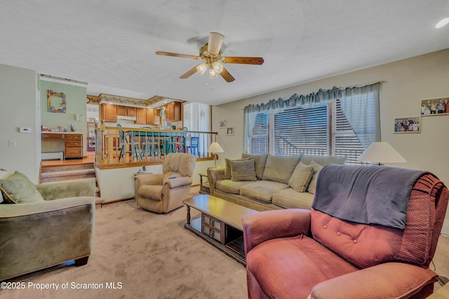 living room featuring light colored carpet, a textured ceiling, and a ceiling fan