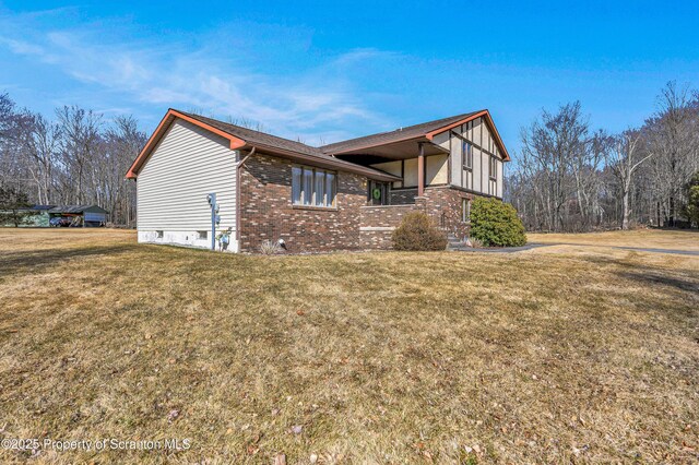 view of property exterior featuring brick siding and a lawn