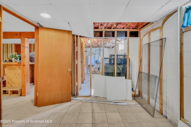 basement featuring a drop ceiling and tile patterned flooring