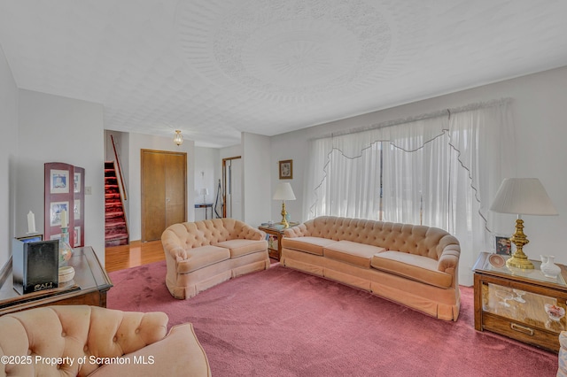 living area with stairs and a textured ceiling