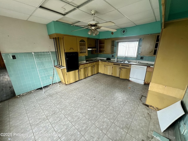 kitchen featuring a sink, a paneled ceiling, light floors, dishwasher, and ceiling fan