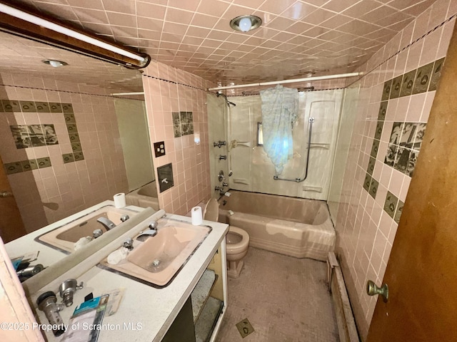 bathroom with vanity, tile walls, toilet, and shower / bathtub combination