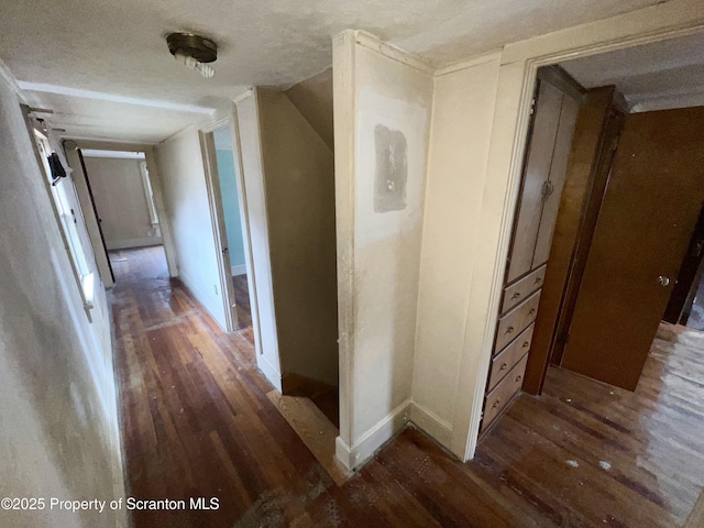 hallway with a textured ceiling, lofted ceiling, baseboards, and hardwood / wood-style flooring