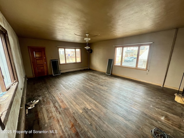 interior space featuring a healthy amount of sunlight, a baseboard radiator, baseboards, and wood-type flooring