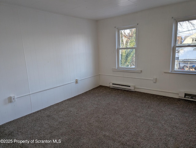 spare room featuring a baseboard radiator, wood walls, carpet, and crown molding