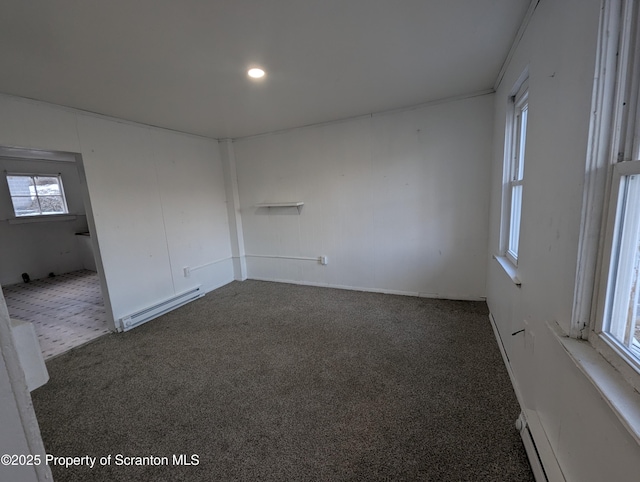 carpeted spare room featuring baseboard heating