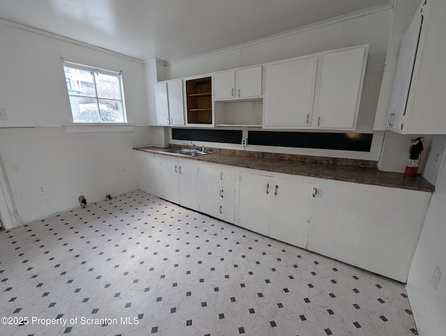 kitchen with sink, white cabinetry, and ornamental molding