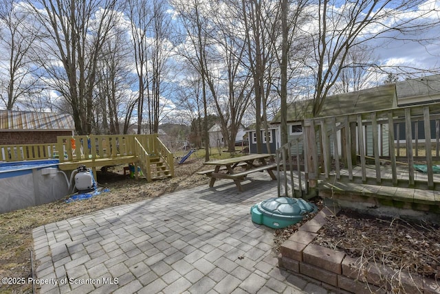 view of patio / terrace featuring a deck and an outdoor pool