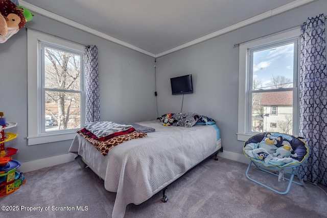 bedroom featuring carpet flooring, crown molding, multiple windows, and baseboards