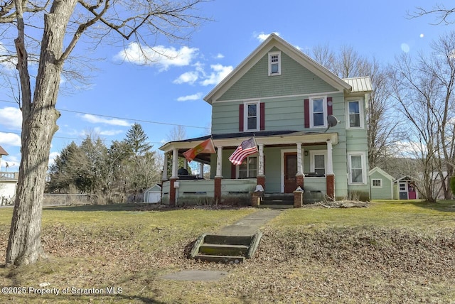 view of front of property featuring a standing seam roof, a porch, metal roof, and a front yard