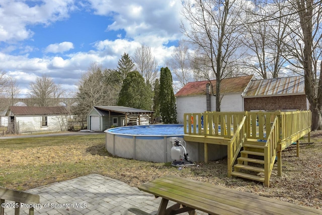 view of yard featuring a deck, an outbuilding, a garage, and an outdoor pool