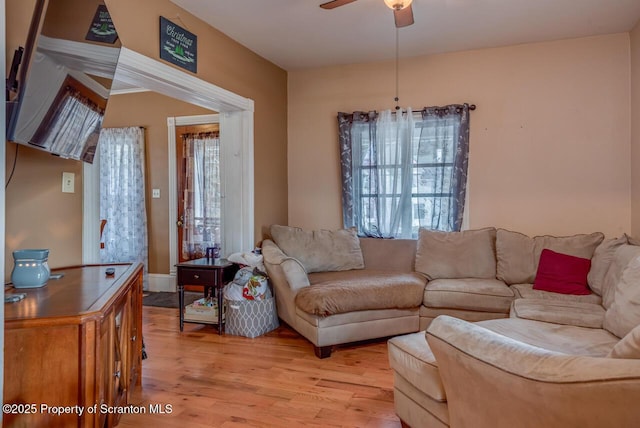 living room with a ceiling fan and light wood-style floors