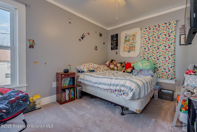 carpeted bedroom featuring a ceiling fan, crown molding, and baseboards